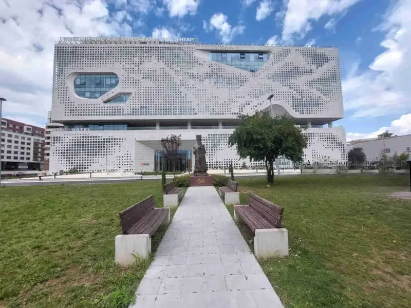 The China Cultural Center in Novi Beograd, Belgrade — a white perforated-facade building with a landscaped entrance path and benches